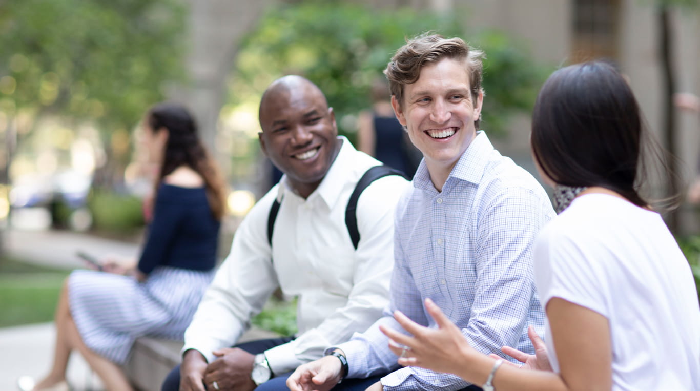 Three part-time MBA students sitting outside on campus